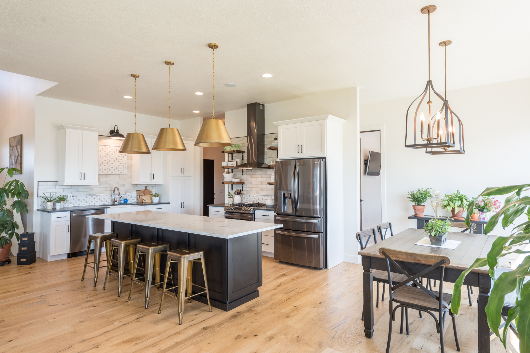 Large kitchen and dining area with hardwood floors, island and white cabinetry